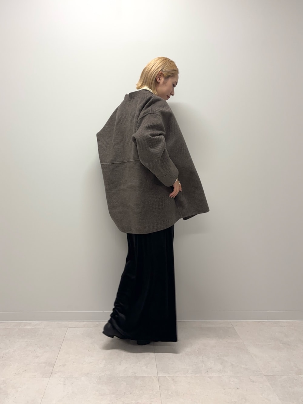 ブラウン系のその他アウター、ホワイト系のニット/セーター、ブラック系のスカートを着用したレディースの秋コーディネートの4枚目の写真