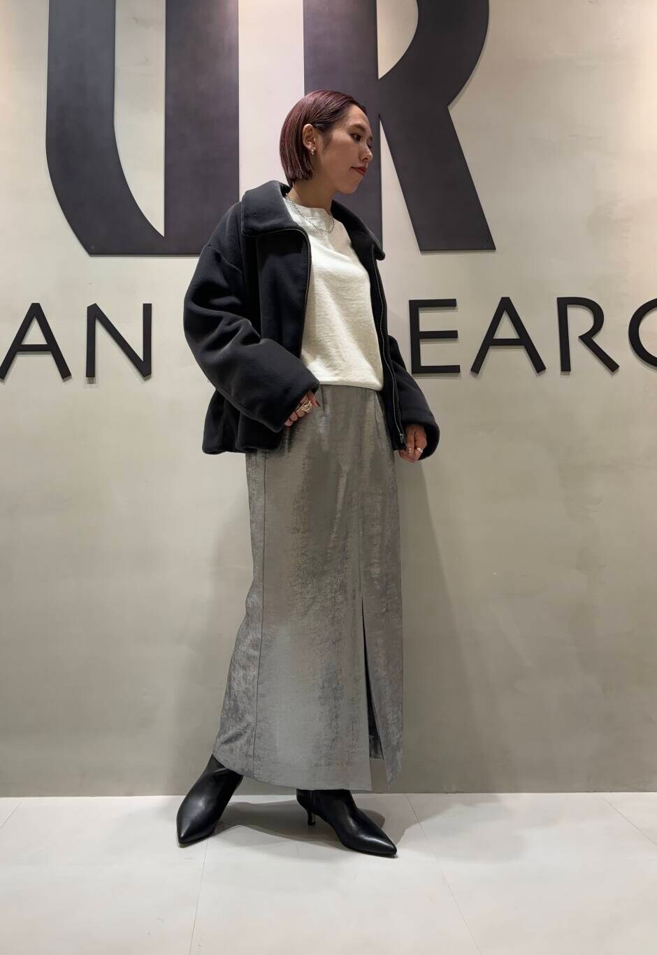 シルバー系のスカート、グレー系のその他アウター、ベージュ系のスウェットを着用したレディースの秋コーディネートの4枚目の写真