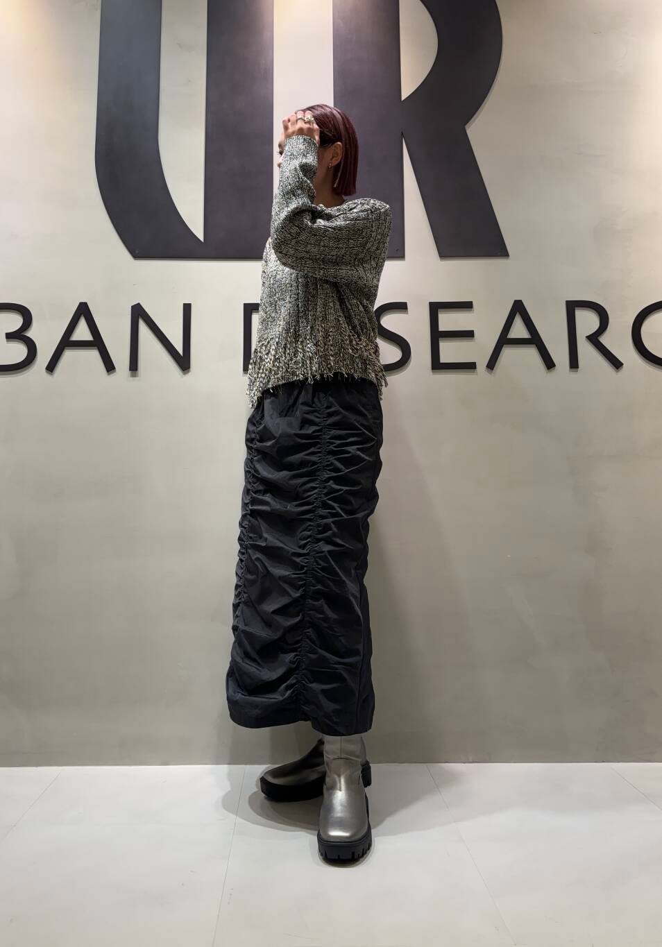 シルバー系のブーツ、ブラック系のスカート、ブラック系のニット/セーターを着用したレディースの秋コーディネートの3枚目の写真