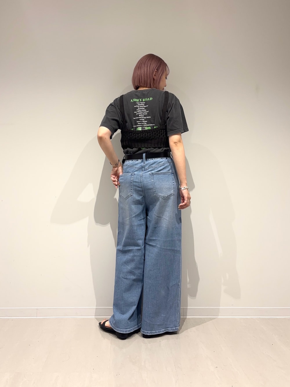 ブラック系のサンダル、ブルー系のデニムパンツ、ブラック系のニット/セーターを着用したレディースの春コーディネートの5枚目の写真