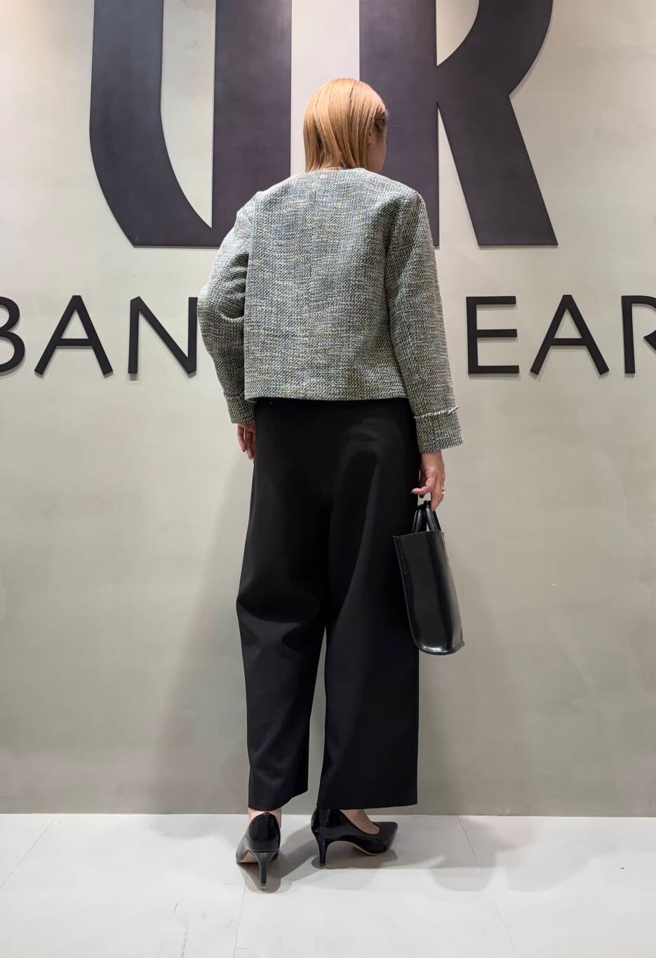 ブラック系のトートバッグ、ブラック系のサロペット/オーバーオール、ブラック系のノーカラージャケットを着用したレディースの冬コーディネートの3枚目の写真