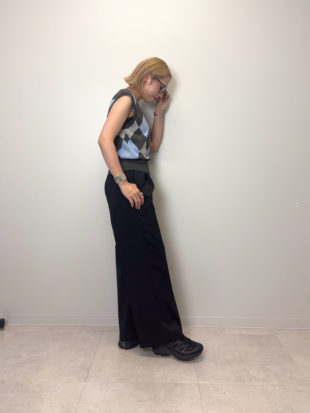 グレー系のベスト、ブラック系のその他パンツ、ブラック系のスニーカーを着用したレディースの夏コーディネートの2枚目の写真
