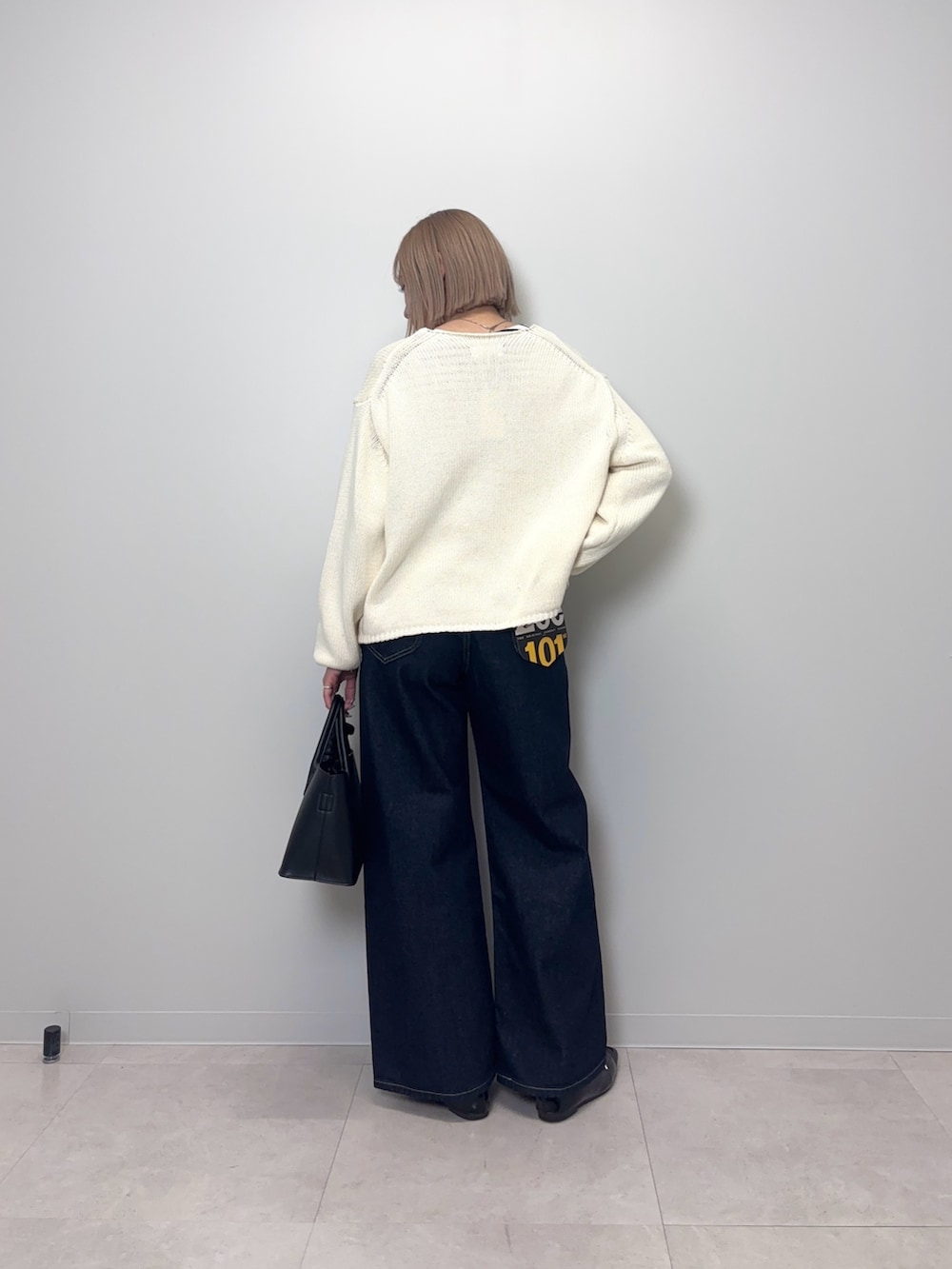 ブルー系のデニムパンツ、ブラック系のTシャツ/カットソー、ホワイト系のカーディガン/ボレロを着用したレディースの春コーディネートの5枚目の写真