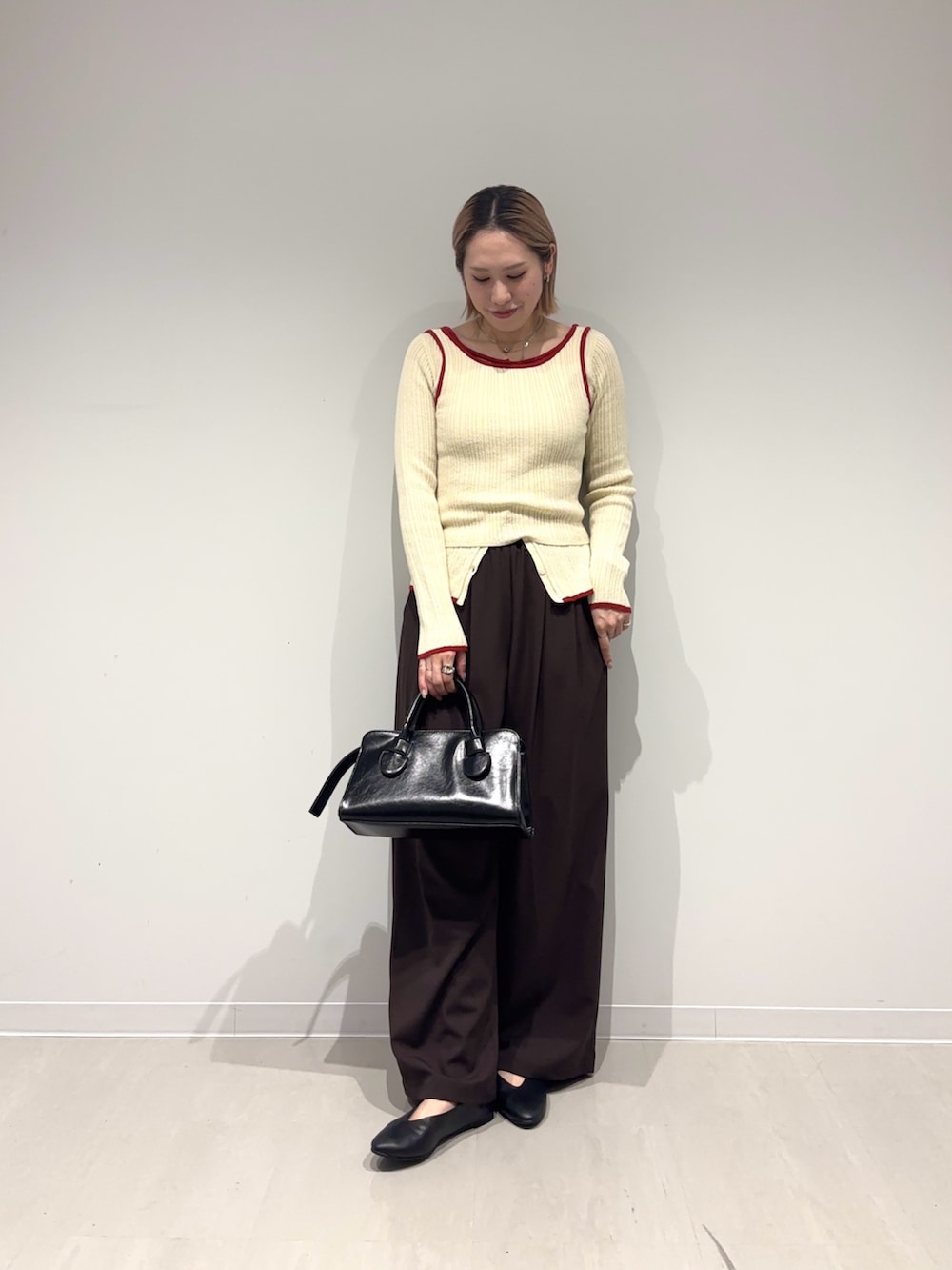 ブラウン系のその他パンツ、ブラック系のパンプス、ブラック系のボストンバッグを着用したレディースの春コーディネートの6枚目の写真