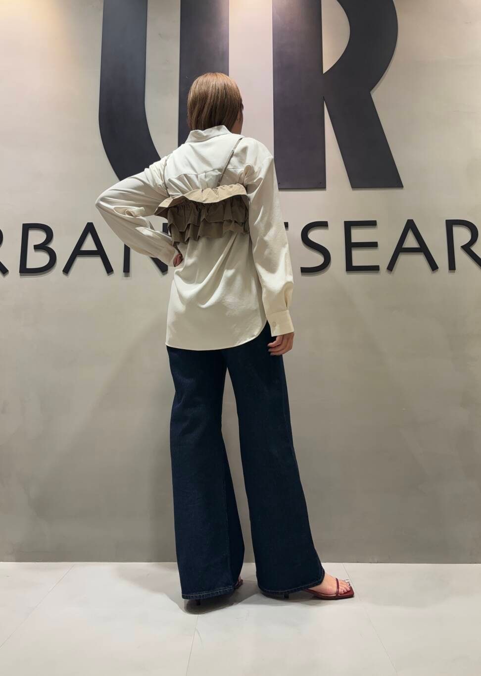 ブラウン系のキャミソール、ホワイト系のシャツ/ブラウス、ブルー系のデニムパンツを着用したレディースの夏コーディネートの3枚目の写真