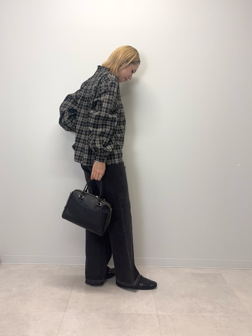 ブラック系のシャツ/ブラウス、ブラック系のデニムパンツ、ブラック系のボストンバッグを着用したレディースの秋コーディネートの5枚目の写真