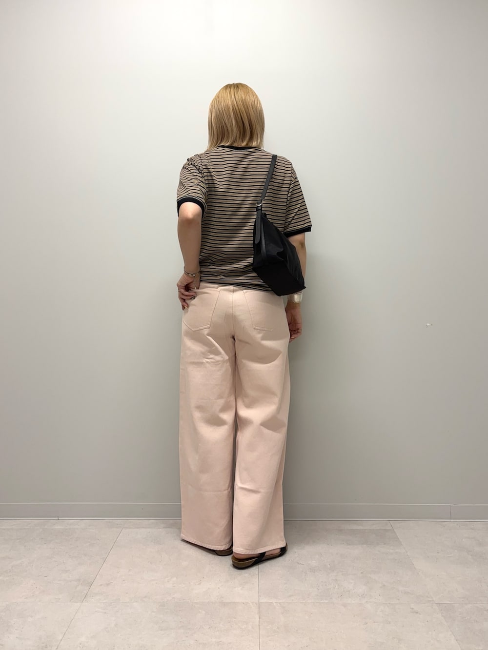 ブラック系のTシャツ/カットソー、ブラック系のショルダーバッグ、ブラック系のサンダルを着用したレディースの夏コーディネートの3枚目の写真