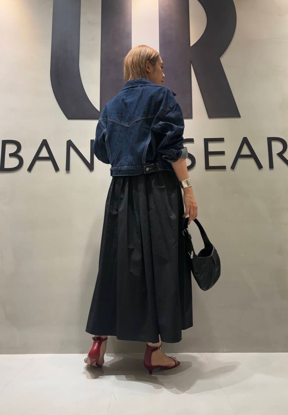 ブラック系のワンピース、ブルー系のデニムジャケットを着用したレディースの夏コーディネートの2枚目の写真