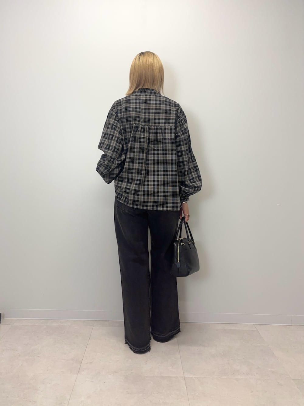 ブラック系のシャツ/ブラウス、ブラック系のデニムパンツ、ブラック系のボストンバッグを着用したレディースの秋コーディネートの3枚目の写真