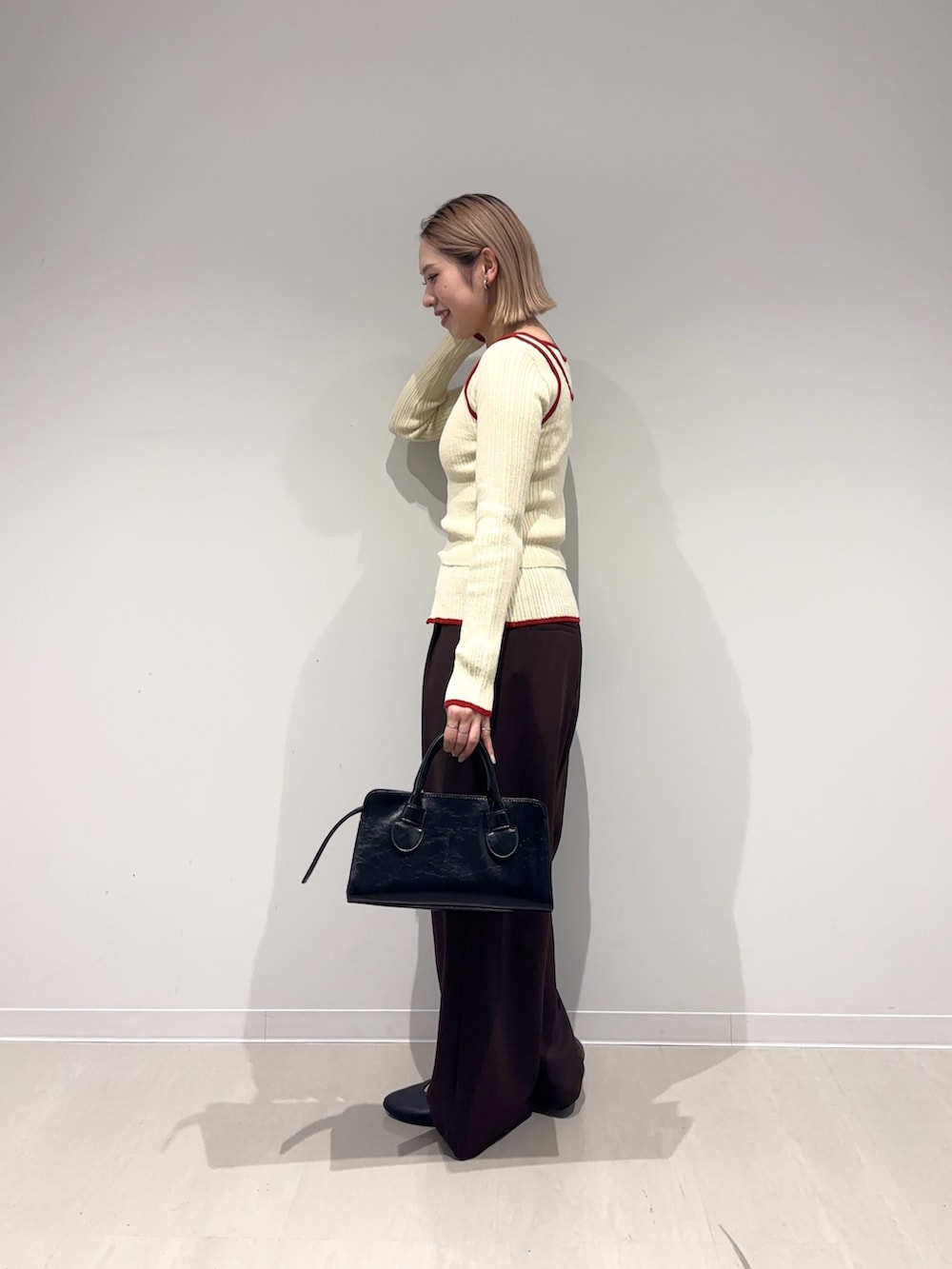 ブラウン系のその他パンツ、ブラック系のパンプス、ブラック系のボストンバッグを着用したレディースの春コーディネートの2枚目の写真