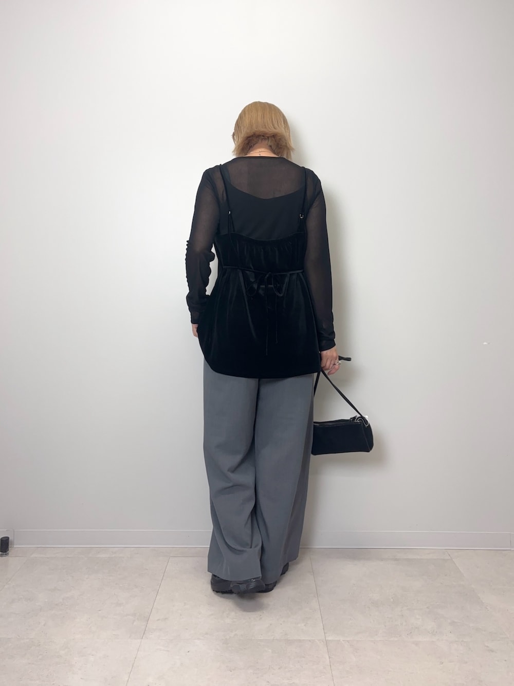 ブラック系のTシャツ/カットソー、グレー系のスラックス、ブラック系のショルダーバッグを着用したレディースの夏コーディネートの3枚目の写真