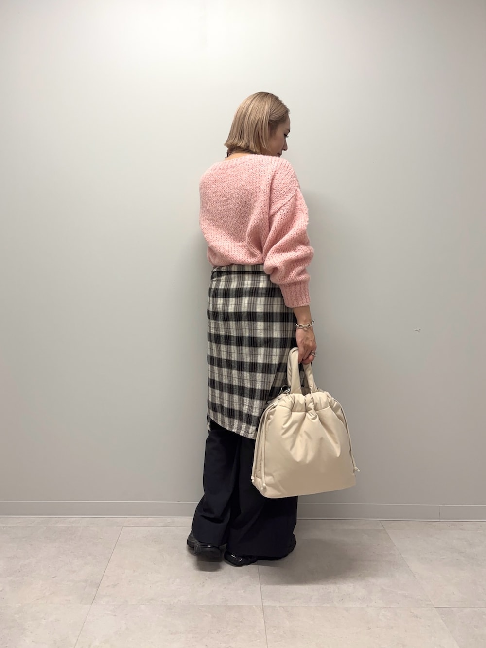 ベージュ系のトートバッグ、グレー系のその他パンツ、ピンク系のニット/セーターを着用したレディースの冬コーディネートの3枚目の写真