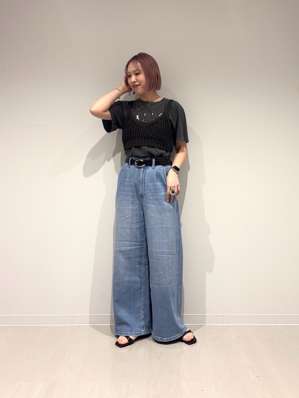 ブラック系のサンダル、ブルー系のデニムパンツ、ブラック系のニット/セーターを着用したレディースの春コーディネートの3枚目の写真