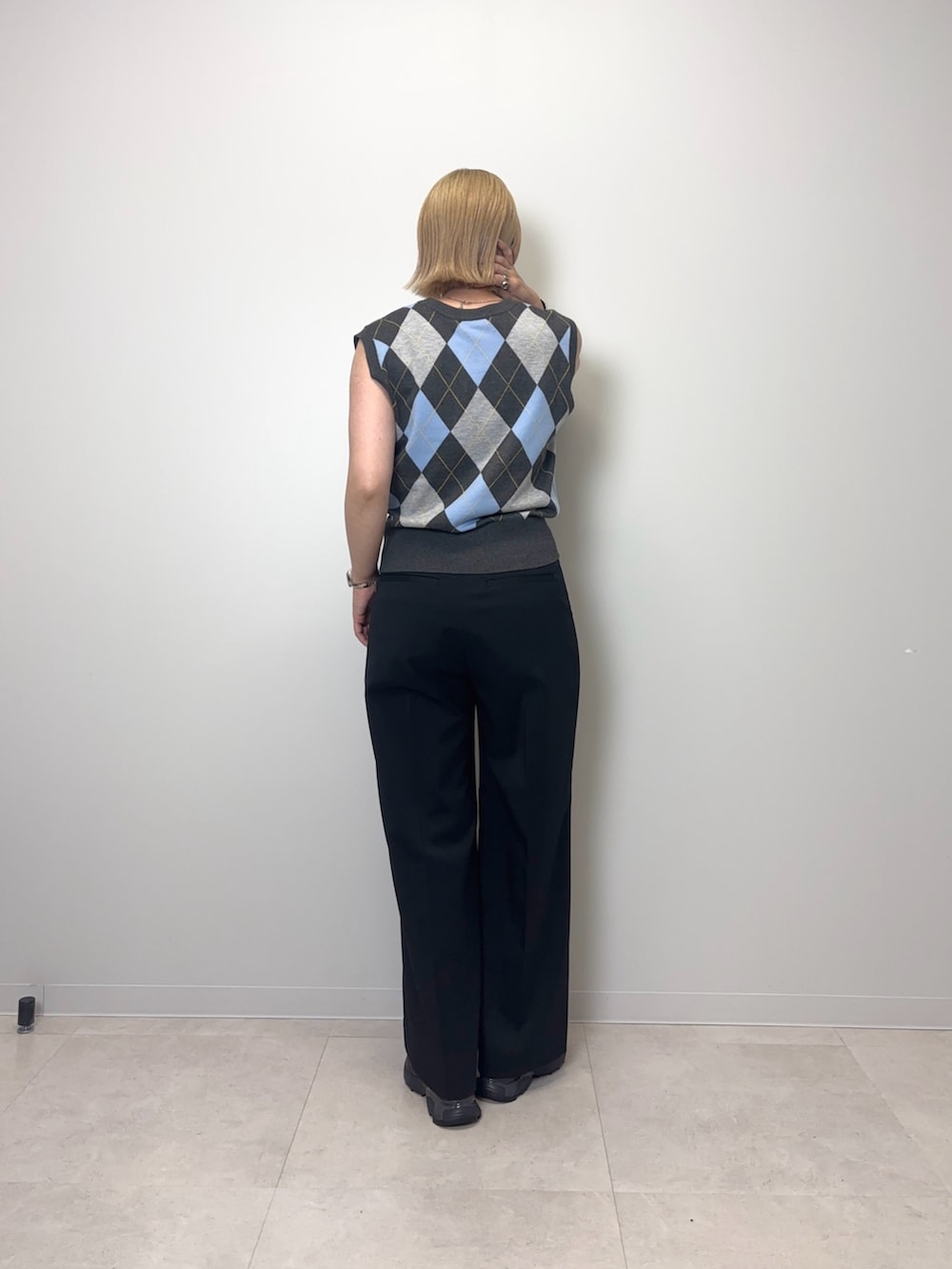 グレー系のベスト、ブラック系のその他パンツ、ブラック系のスニーカーを着用したレディースの夏コーディネートの3枚目の写真
