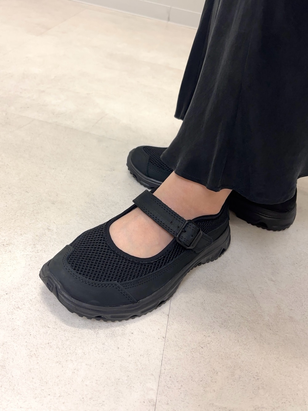 ブルー系のシャツ/ブラウス、ブラック系のスカート、ブラック系のスニーカーを着用したレディースの春コーディネートの5枚目の写真