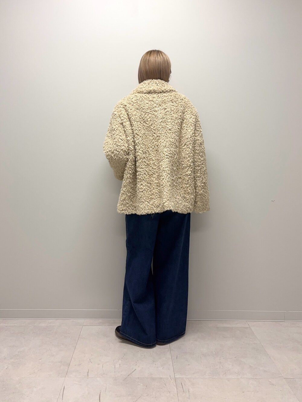 ブラック系のスニーカー、ブルー系のデニムパンツ、ホワイト系のその他アウターを着用したレディースの冬コーディネートの3枚目の写真