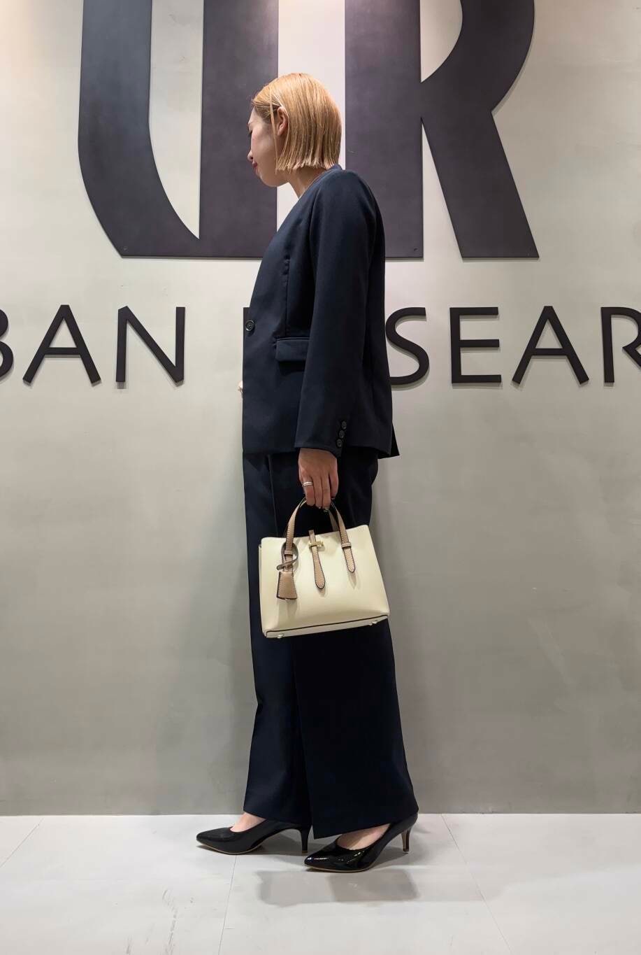 ホワイト系のハンドバッグ、ブルー系のその他パンツ、ブルー系のノーカラージャケットを着用したレディースの冬コーディネートの2枚目の写真