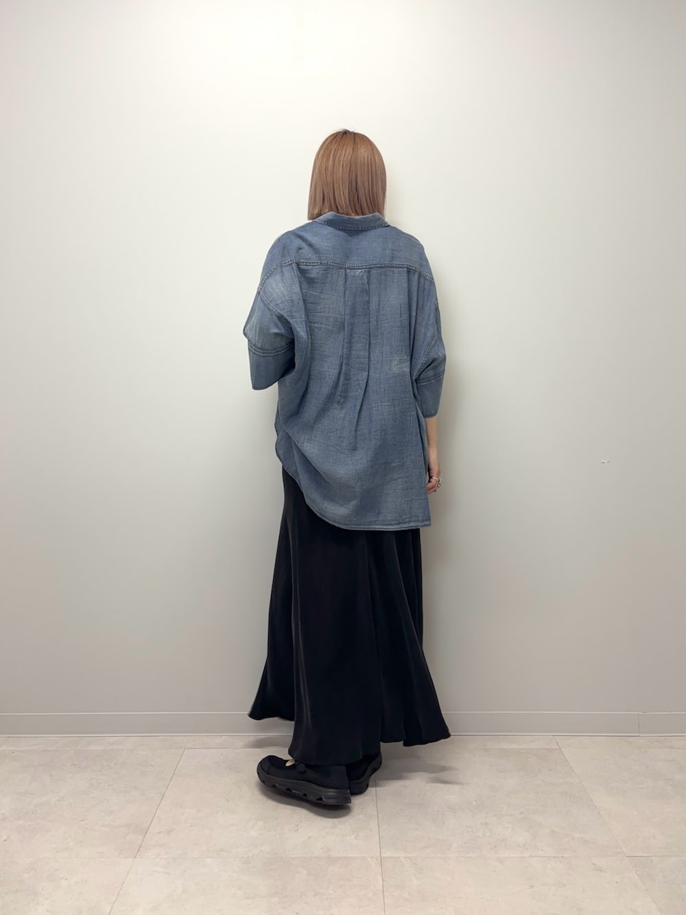 ブルー系のシャツ/ブラウス、ブラック系のスカート、ブラック系のスニーカーを着用したレディースの春コーディネートの3枚目の写真