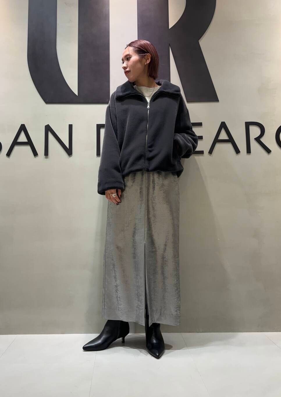 シルバー系のスカート、グレー系のその他アウター、ベージュ系のスウェットを着用したレディースの秋コーディネートの3枚目の写真