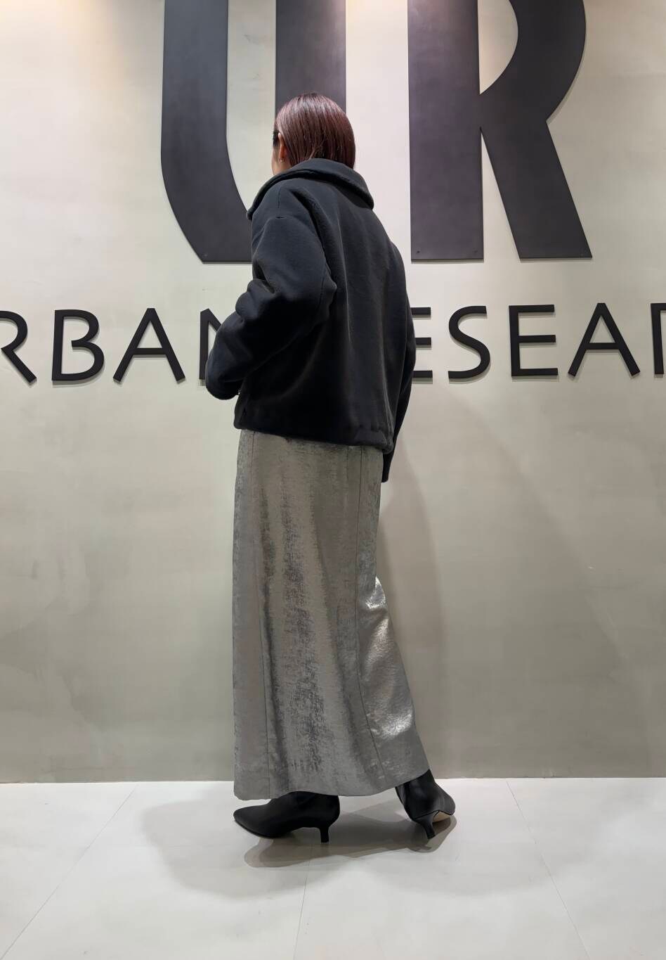 シルバー系のスカート、グレー系のその他アウター、ベージュ系のスウェットを着用したレディースの秋コーディネートの2枚目の写真