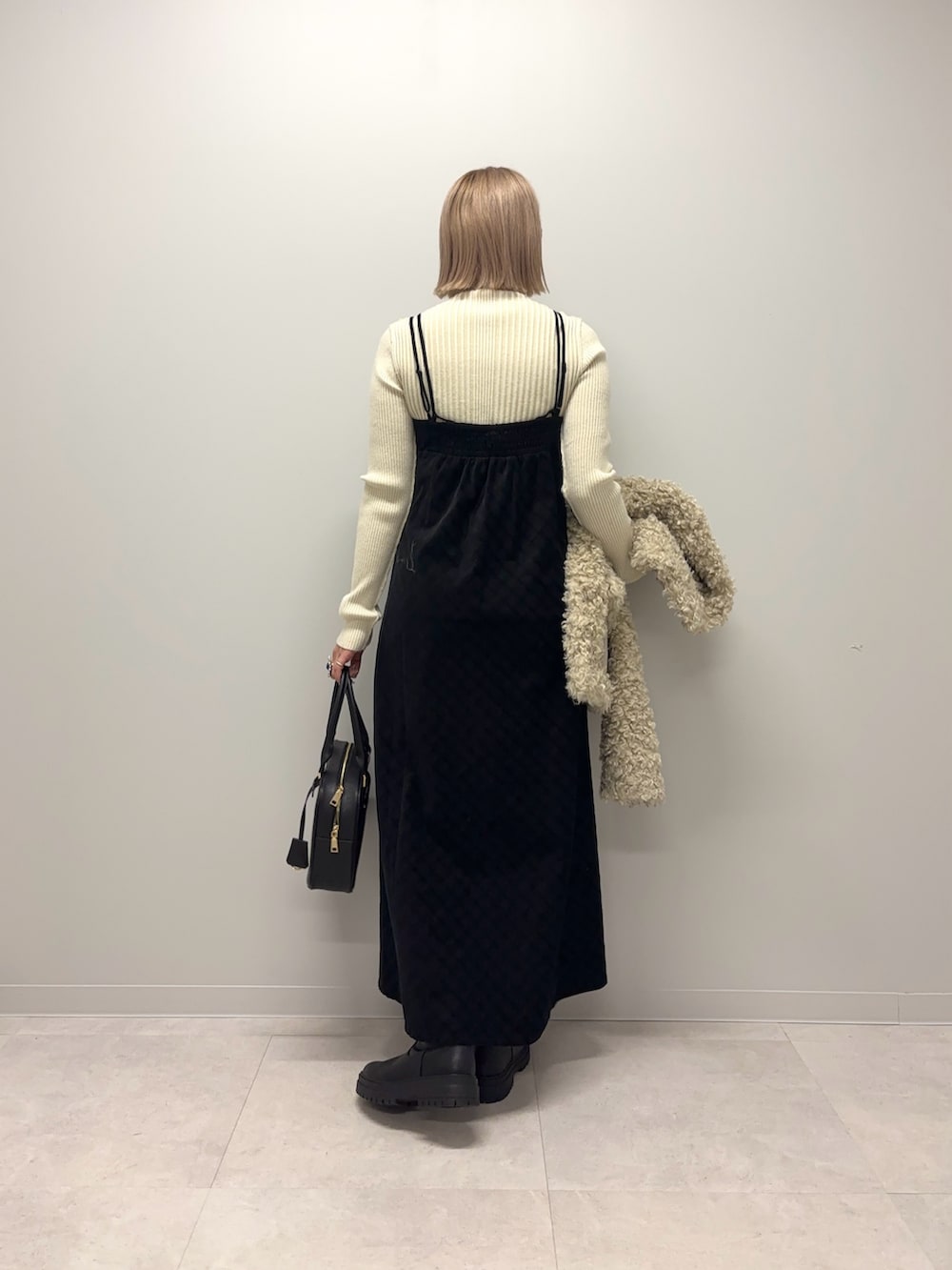 ホワイト系のニット/セーター、ブラック系のワンピース、ホワイト系のその他アウターを着用したレディースの冬コーディネートの5枚目の写真