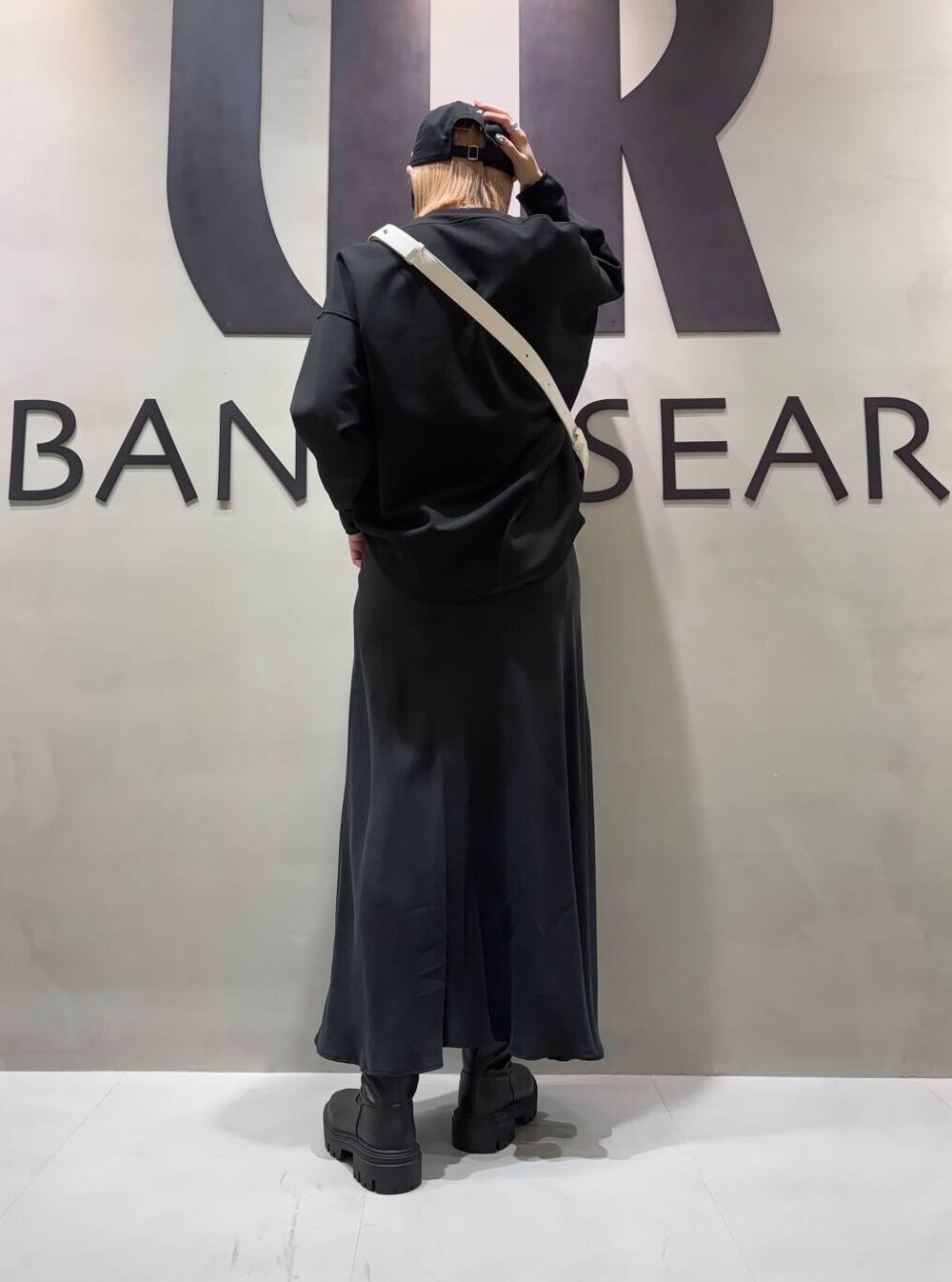 ブラック系のブーツ、ブラック系のTシャツ/カットソー、ブラック系のスカートを着用したレディースの冬コーディネートの3枚目の写真