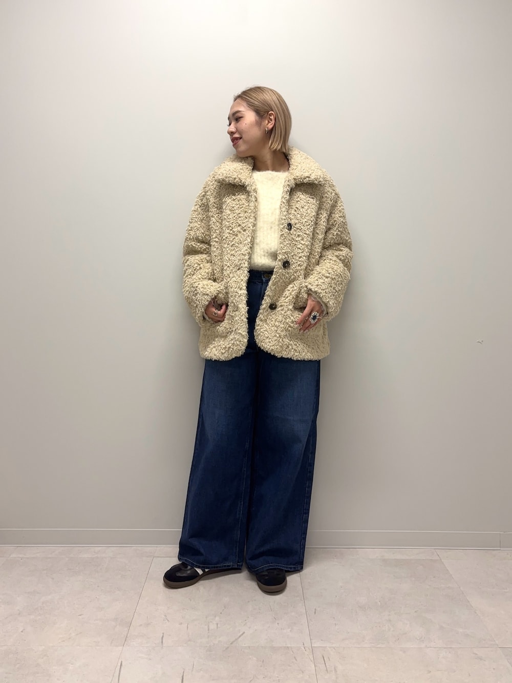 ブラック系のスニーカー、ブルー系のデニムパンツ、ホワイト系のその他アウターを着用したレディースの冬コーディネートの6枚目の写真