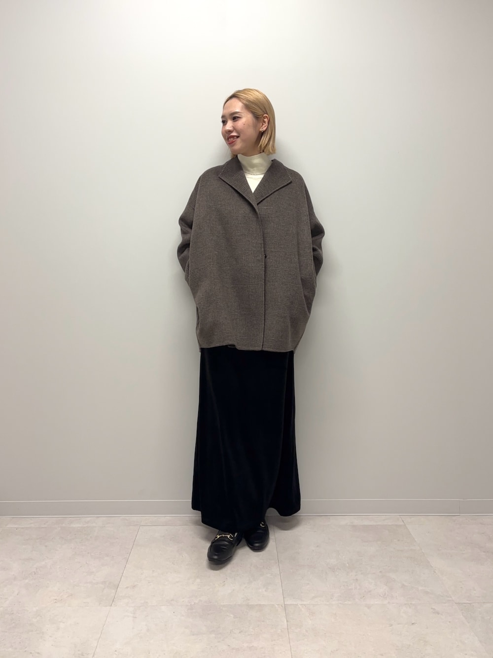 ブラウン系のその他アウター、ホワイト系のニット/セーター、ブラック系のスカートを着用したレディースの秋コーディネートの7枚目の写真