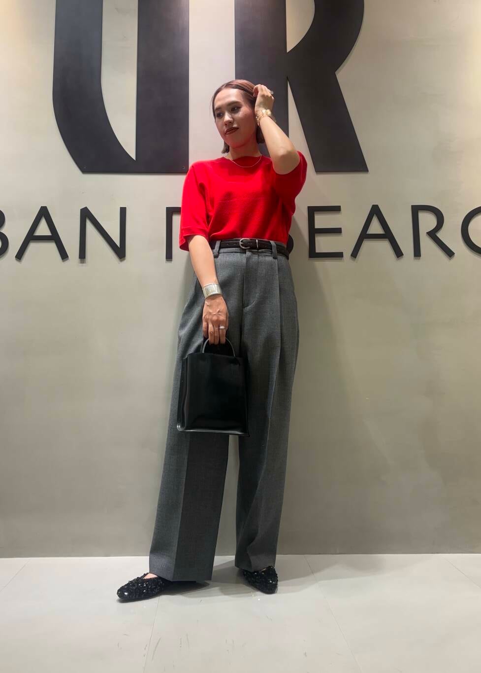 ブラック系のトートバッグ、グレー系のその他パンツ、レッド系のニット/セーターを着用したレディースの秋コーディネートの4枚目の写真