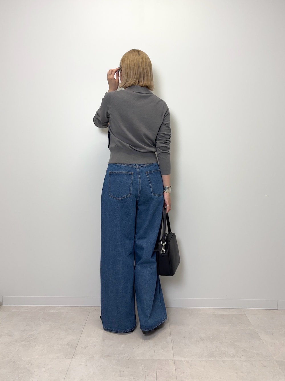 グレー系のカーディガン/ボレロ、ブルー系のデニムパンツ、ブラック系のショルダーバッグを着用したレディースの秋コーディネートの3枚目の写真
