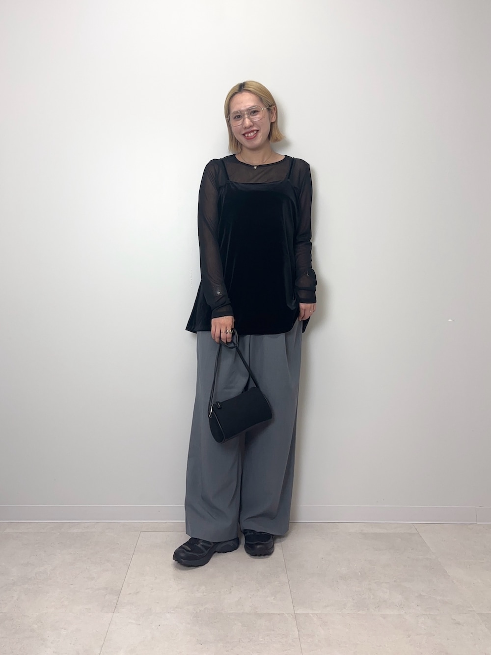 ブラック系のTシャツ/カットソー、グレー系のスラックス、ブラック系のショルダーバッグを着用したレディースの夏コーディネートの4枚目の写真
