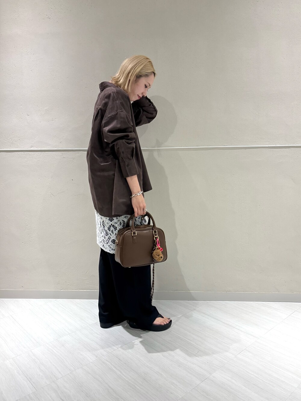 ブラウン系のシャツ/ブラウス、ブラック系のその他パンツ、ブラウン系のボストンバッグを着用したレディースの夏コーディネートの2枚目の写真