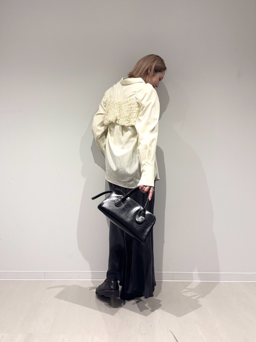 ブラック系のスカート、ブラック系のボストンバッグ、ホワイト系のシャツ/ブラウスを着用したレディースの春コーディネートの6枚目の写真