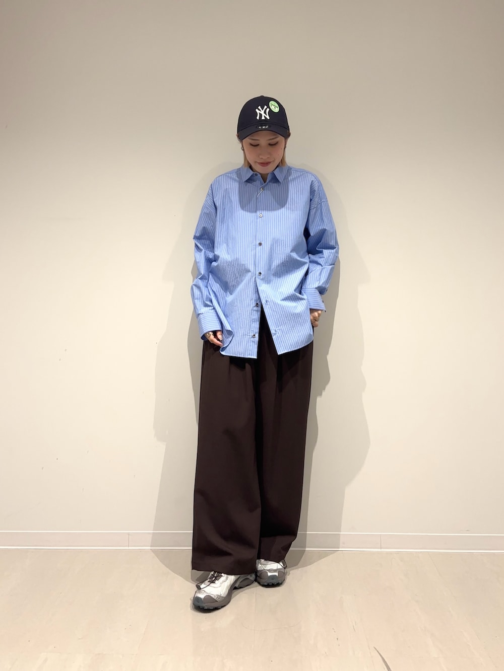 ブラウン系のその他パンツ、ブルー系のシャツ/ブラウス、グレー系のスニーカーを着用したレディースの春コーディネートの6枚目の写真