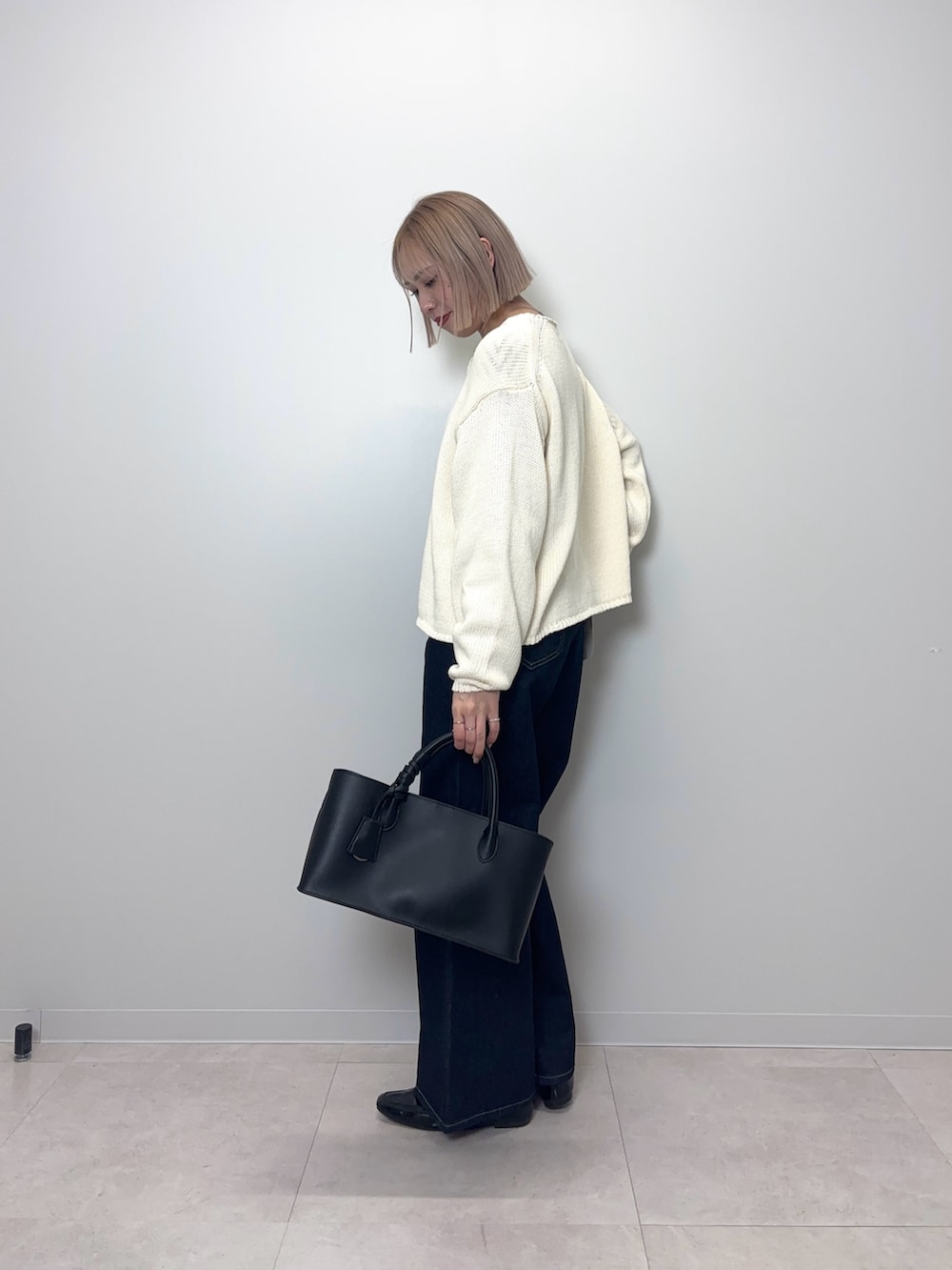 ブルー系のデニムパンツ、ブラック系のTシャツ/カットソー、ホワイト系のカーディガン/ボレロを着用したレディースの春コーディネートの3枚目の写真