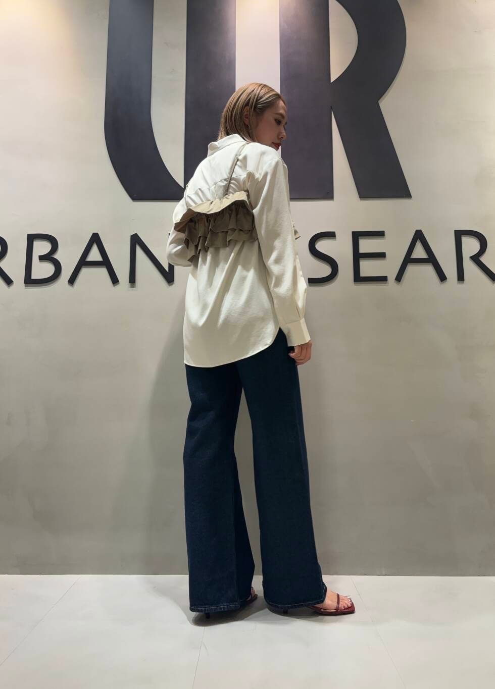 ブラウン系のキャミソール、ホワイト系のシャツ/ブラウス、ブルー系のデニムパンツを着用したレディースの夏コーディネートの2枚目の写真