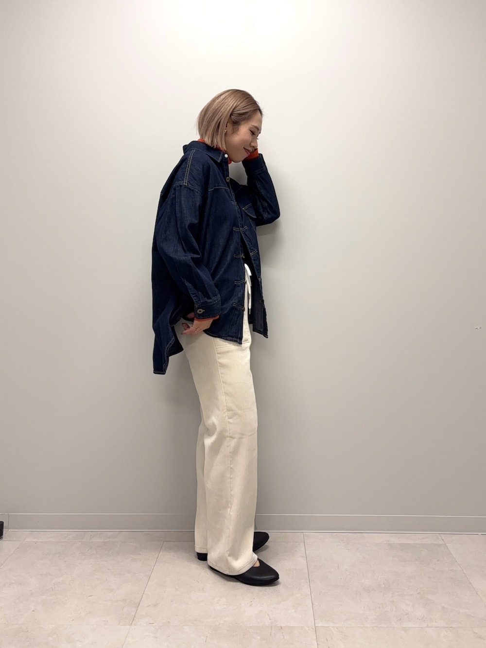 オレンジ系のニット/セーター、ブルー系のシャツ/ブラウス、ホワイト系のその他パンツを着用したレディースの冬コーディネートの3枚目の写真