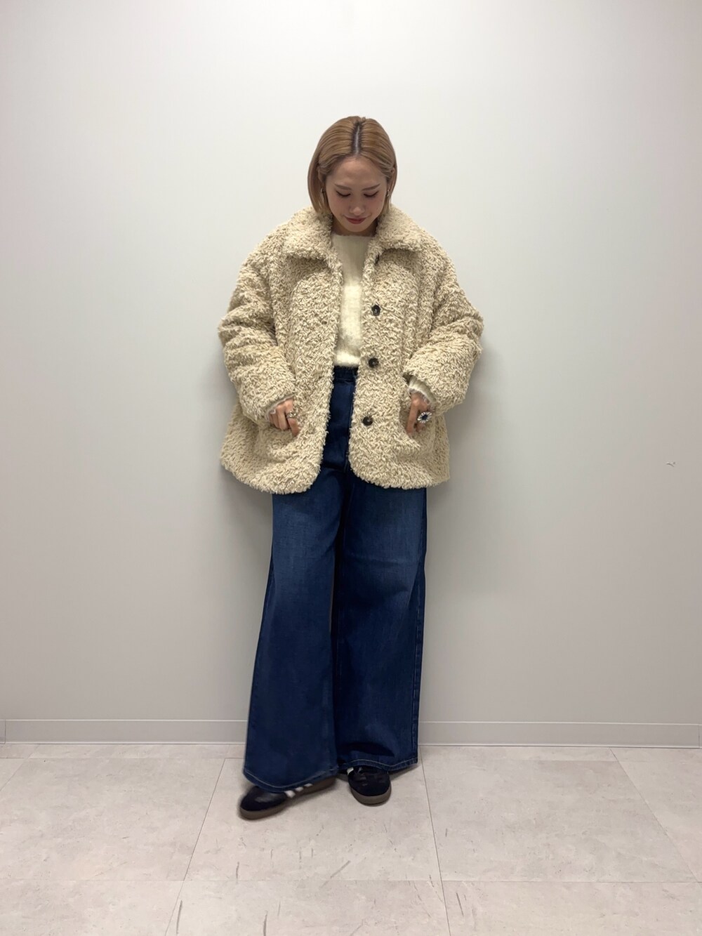 ブラック系のスニーカー、ブルー系のデニムパンツ、ホワイト系のその他アウターを着用したレディースの冬コーディネートの5枚目の写真