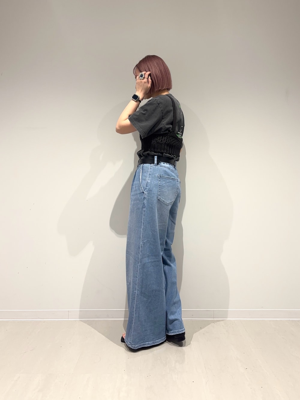 ブラック系のサンダル、ブルー系のデニムパンツ、ブラック系のニット/セーターを着用したレディースの春コーディネートの4枚目の写真