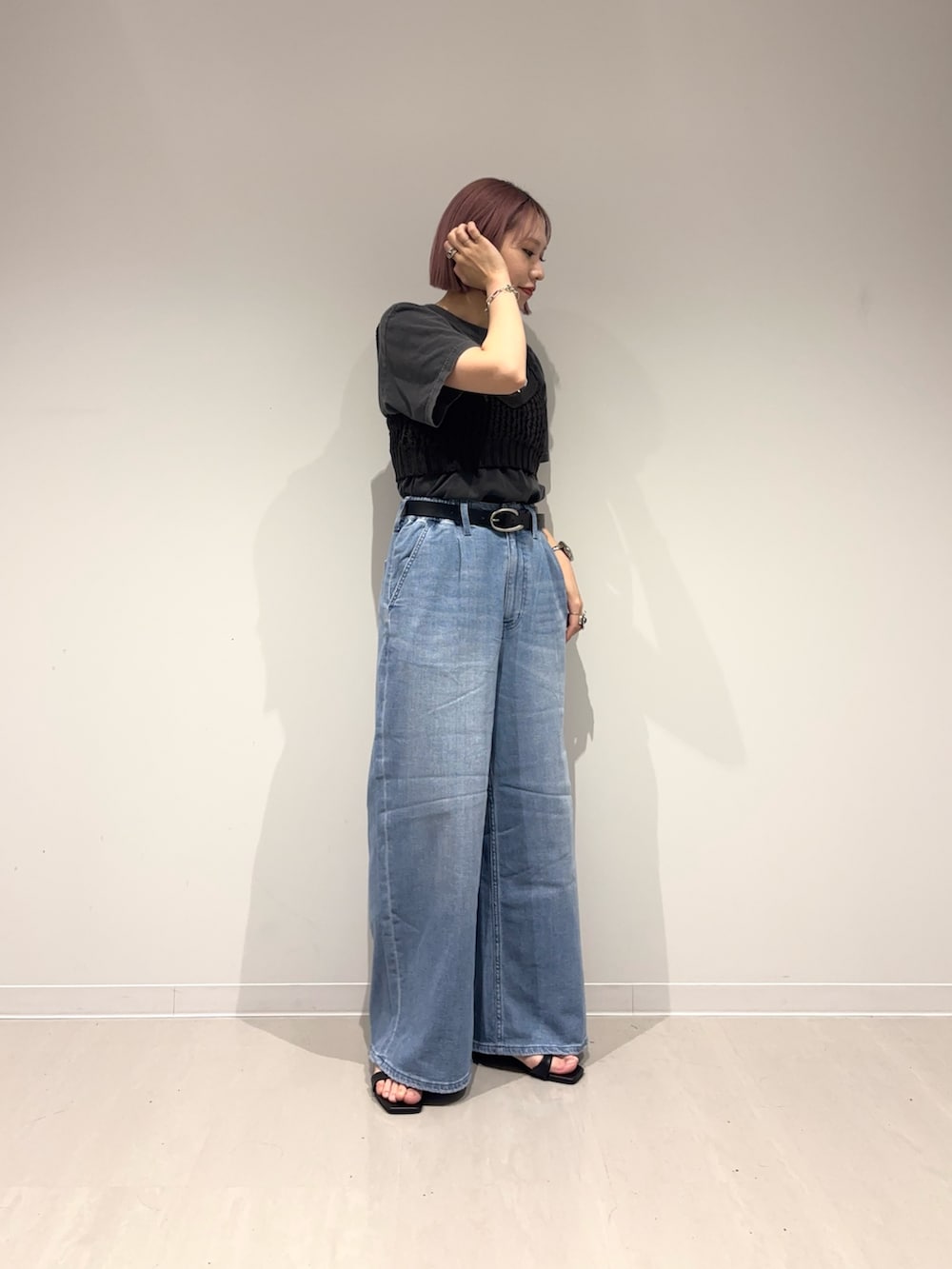 ブラック系のサンダル、ブルー系のデニムパンツ、ブラック系のニット/セーターを着用したレディースの春コーディネートの2枚目の写真