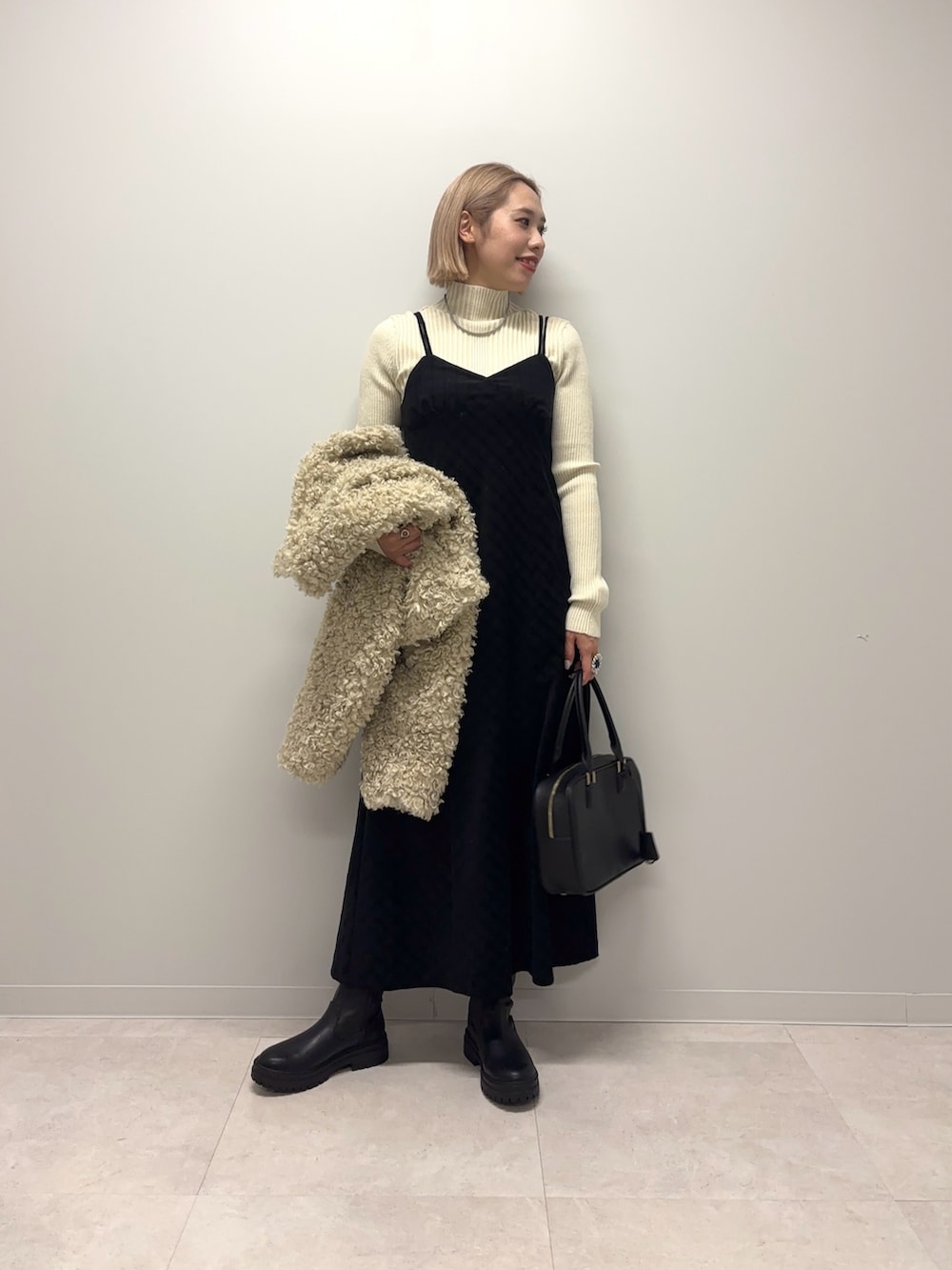 ホワイト系のニット/セーター、ブラック系のワンピース、ホワイト系のその他アウターを着用したレディースの冬コーディネートの4枚目の写真