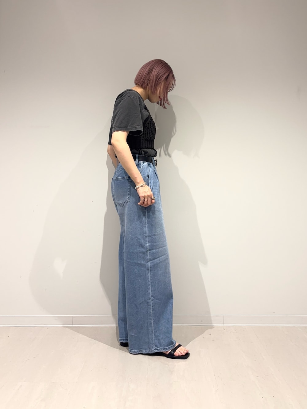 ブラック系のサンダル、ブルー系のデニムパンツ、ブラック系のニット/セーターを着用したレディースの春コーディネートの6枚目の写真