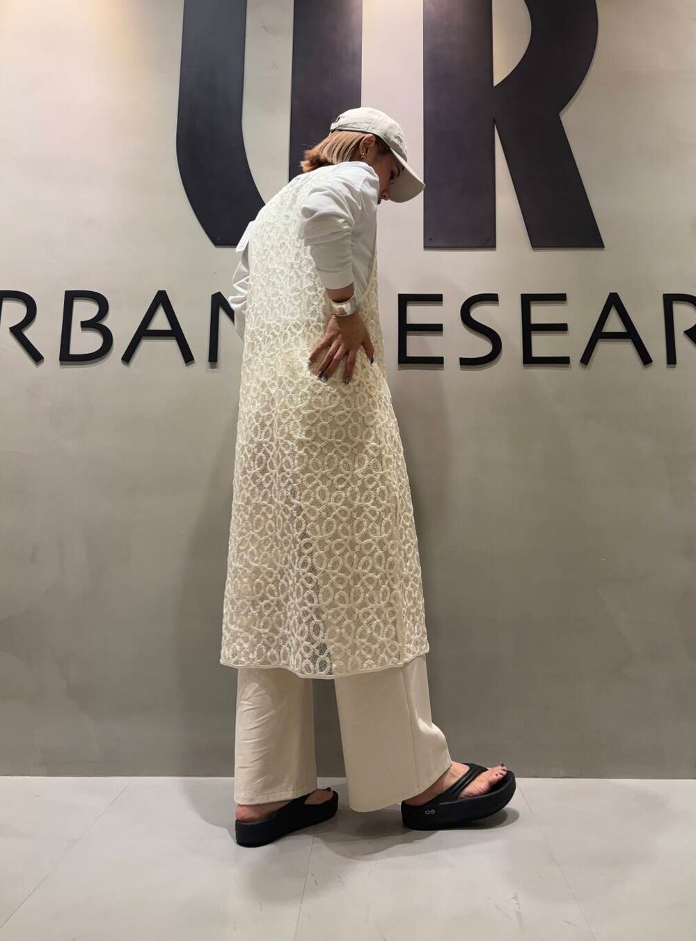 ベージュ系のその他パンツ、ホワイト系のワンピース、ホワイト系のキャップを着用したレディースの夏コーディネートの3枚目の写真