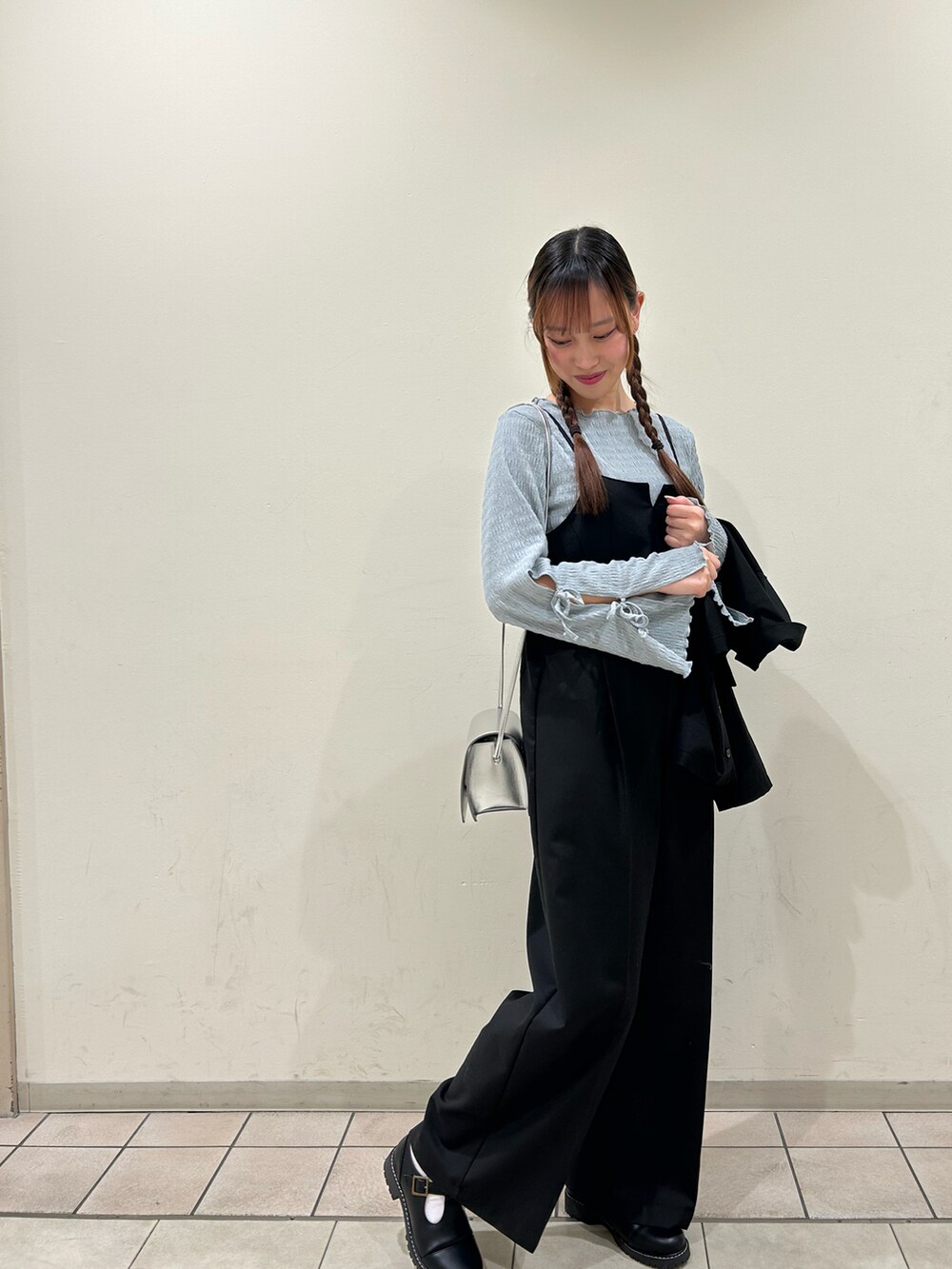 シルバー系のハンドバッグ、ブラック系のその他シューズ、グレー系のTシャツ/カットソーを着用したレディースの春コーディネートの2枚目の写真