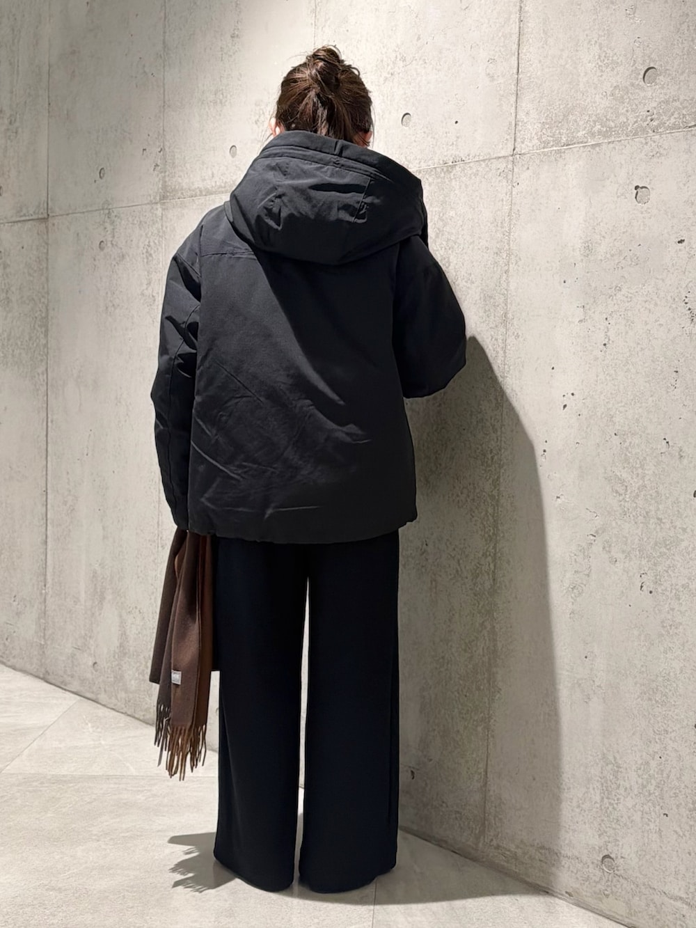 ブラック系のダウンジャケット/コート、ブルー系のニット/セーター、ブラック系のその他パンツを着用したレディースの秋コーディネートの4枚目の写真