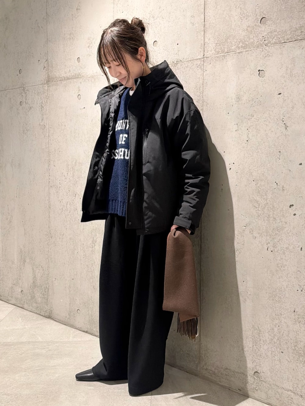 ブラック系のダウンジャケット/コート、ブルー系のニット/セーター、ブラック系のその他パンツを着用したレディースの秋コーディネートの2枚目の写真