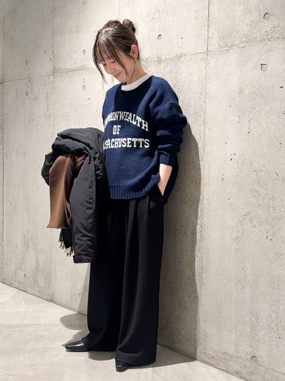 ブラック系のダウンジャケット/コート、ブルー系のニット/セーター、ブラック系のその他パンツを着用したレディースの秋コーディネートの5枚目の写真