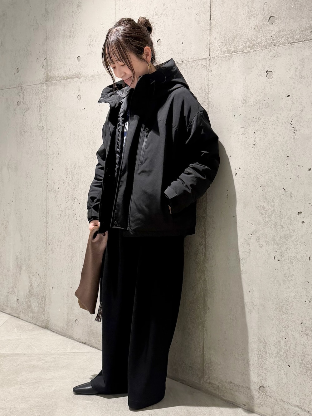 ブラック系のダウンジャケット/コート、ブルー系のニット/セーター、ブラック系のその他パンツを着用したレディースの秋コーディネートの3枚目の写真