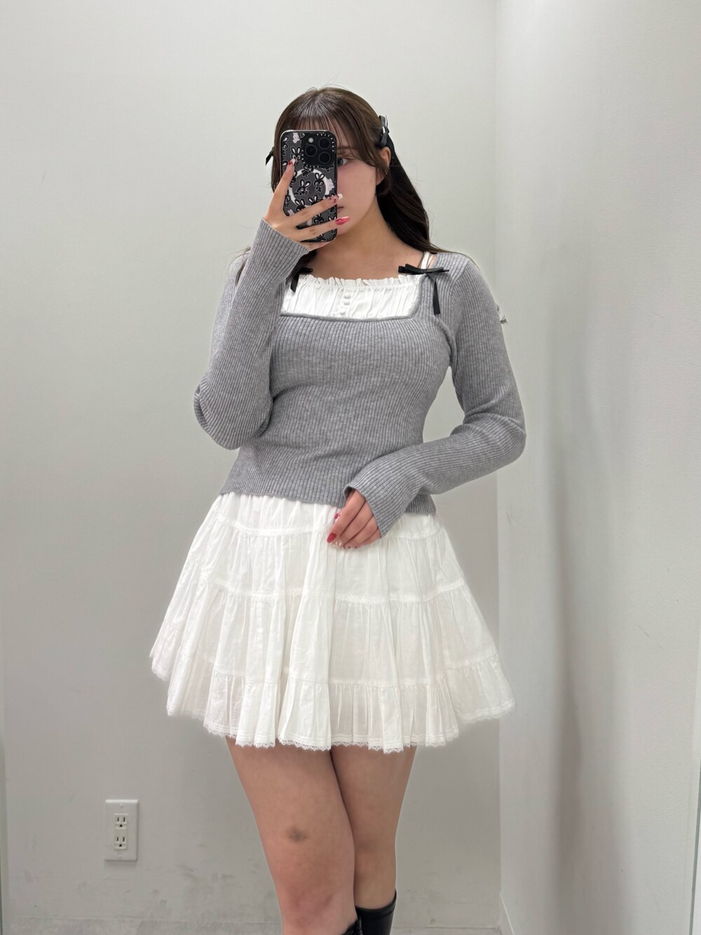 ホワイト系のスカート、グレー系のニット/セーターを着用したレディースの冬コーディネートの2枚目の写真