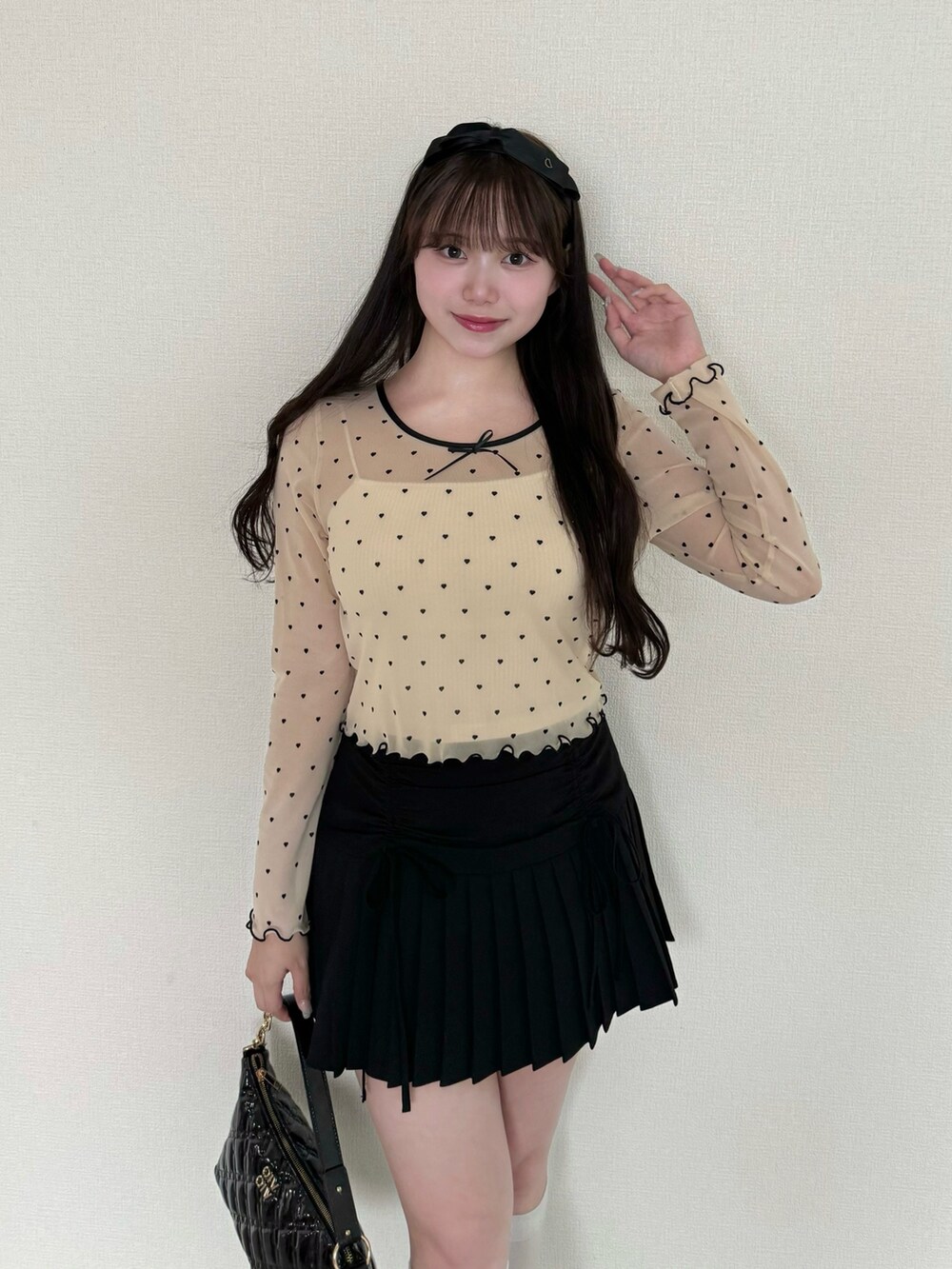 ホワイト系のTシャツ/カットソー、ブラック系のスカート、ブラック系のショルダーバッグを着用したレディースの秋コーディネートの2枚目の写真